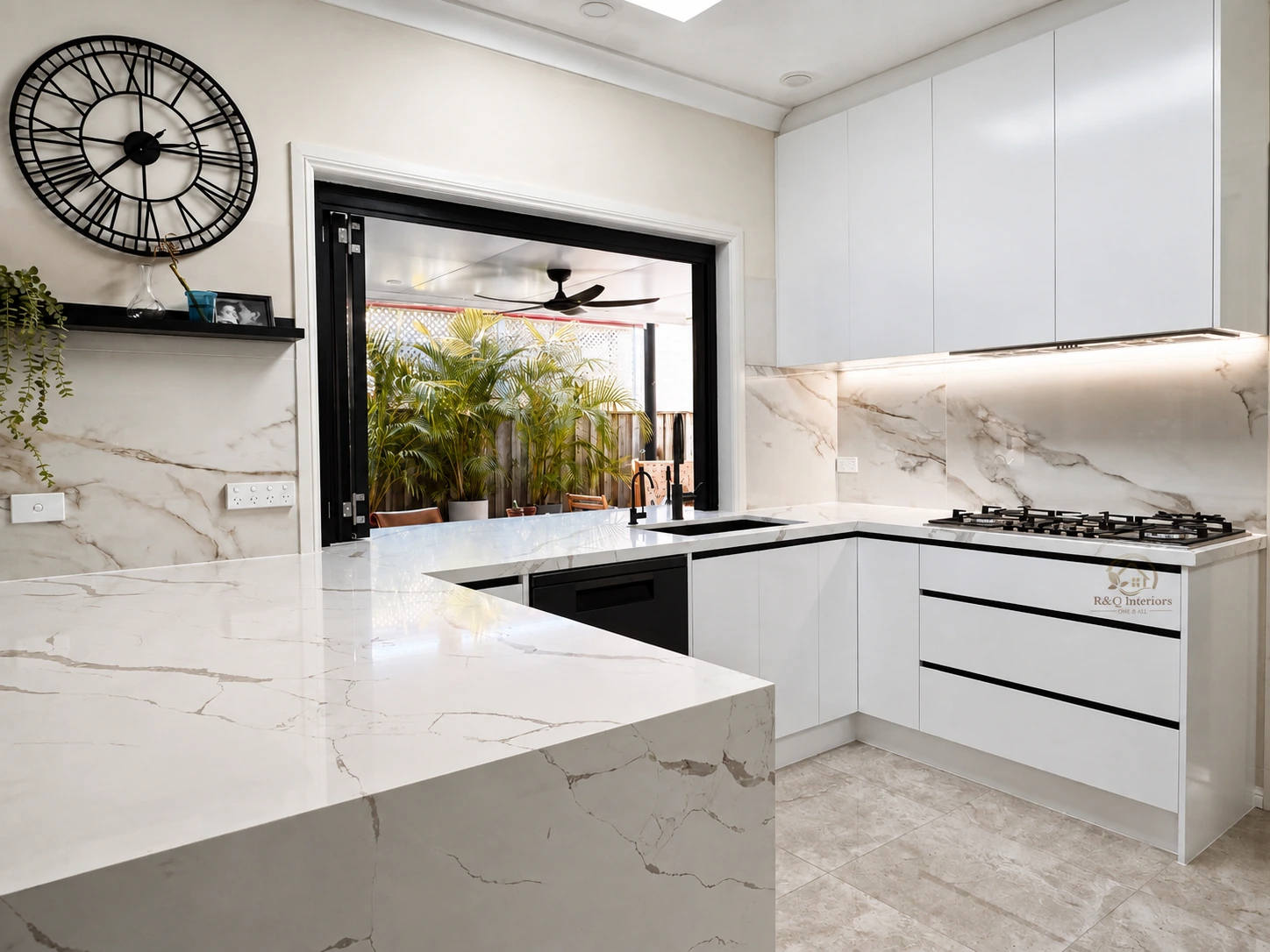 Indoor-outdoor kitchen renovation in Castle Hill — marble-look waterfall island and a servery window to the alfresco